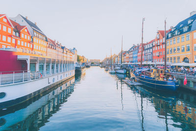 Canal amidst buildings in city against sky