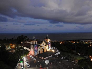 Town by sea against sky at night