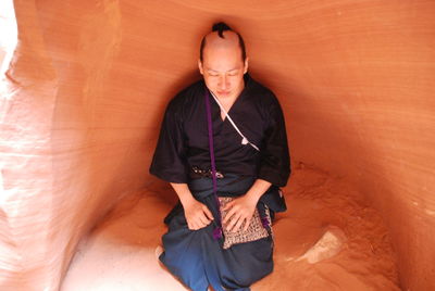 High angle view of mid adult man sitting on rock