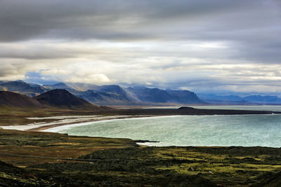 Scenic view of sea and mountains against sky