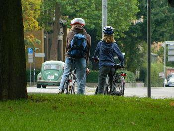 Rear view of people on road against trees