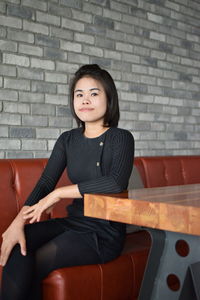 Portrait of young woman looking away while sitting in cafe