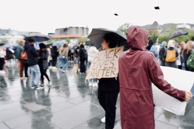 People protesting for black lives matter on wet street in city