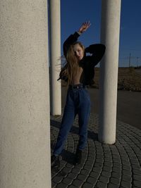 Full length portrait of woman standing on footpath