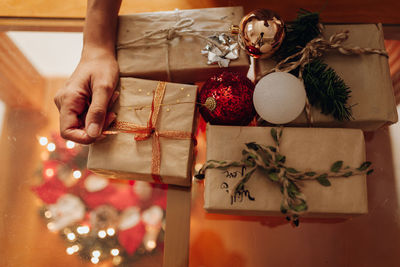 Cropped hand of woman holding christmas decoration home