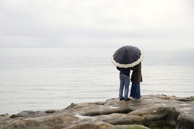 Rear view of couple with umbrella
