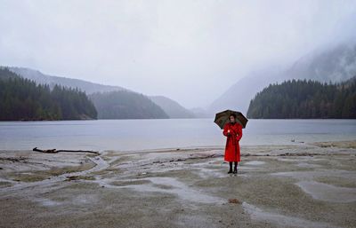 Woman standing on cliff by sea