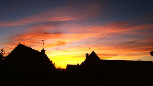 Low angle view of silhouette buildings against sky at sunset