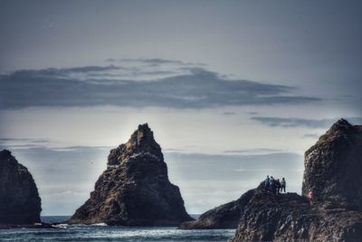 Rock formations on beach against sky