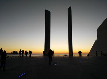 Silhouette people against clear sky during sunset