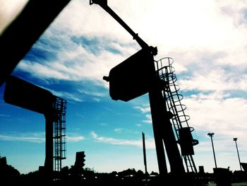 Low angle view of silhouette built structure against blue sky