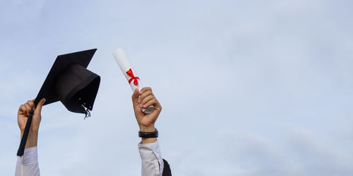 Graduation day.man holding certificate paper and mortar board .