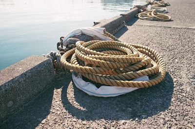 High angle view of rope tied to bollard at harbor