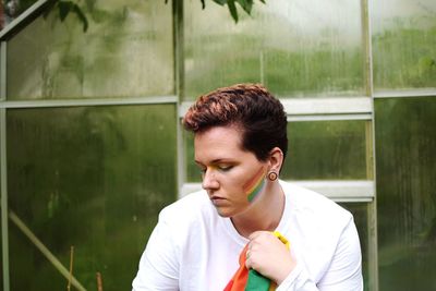 Portrait of young man looking through window