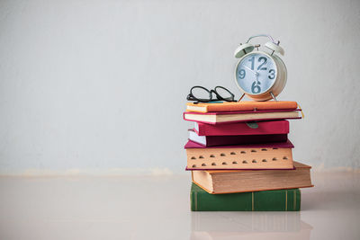 Close-up of clock on table against wall