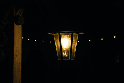 Low angle view of illuminated lamp at night