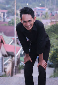 Portrait of young man standing in city