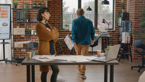 Young woman using laptop while sitting on table