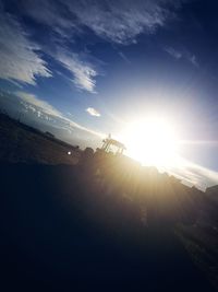 Low angle view of sun shining through landscape