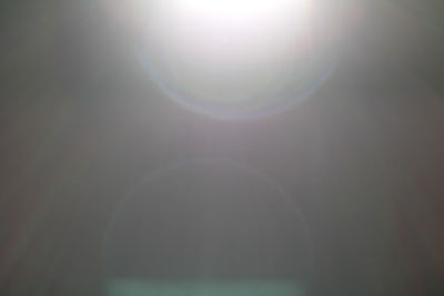 Low angle view of bright sun in sky