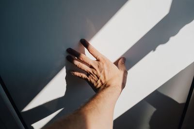 Cropped image of hand touching wall