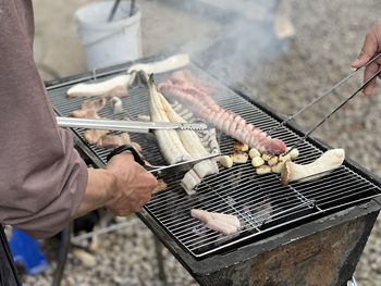 Midsection of man cooking on barbecue grill