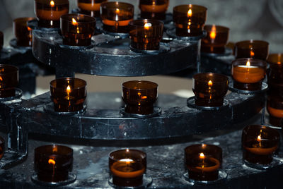 Close-up of lit tea light candles at altar in church