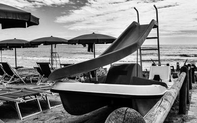 Boats moored on beach against sky