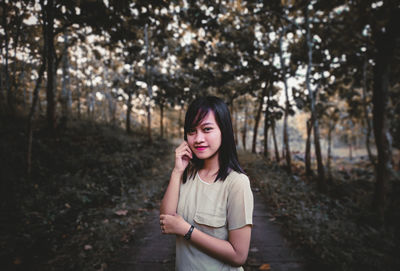 Portrait of beautiful young woman standing on land