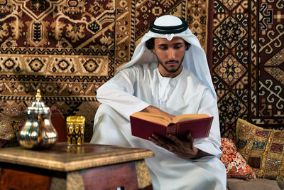 Portrait of young woman reading book