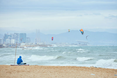 Man surfing on beach against sky