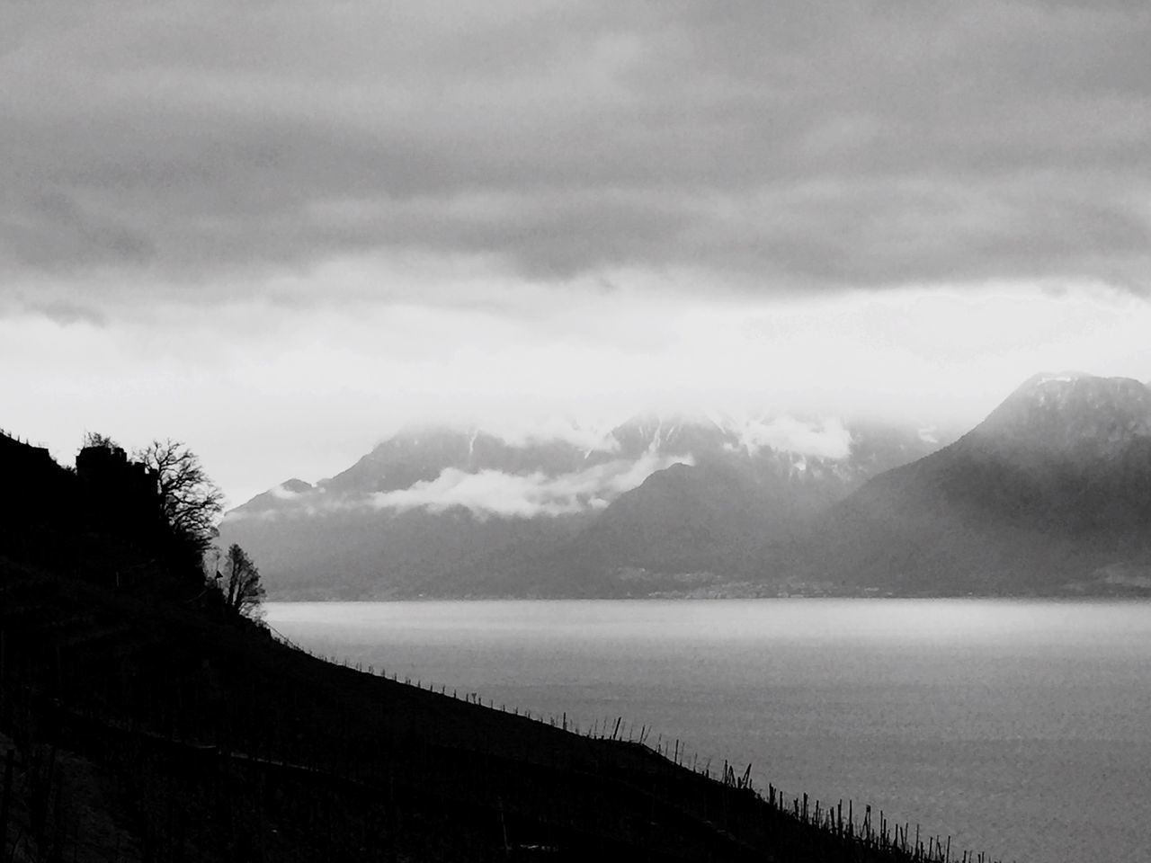 mountain, mountain range, tranquil scene, scenics, tranquility, beauty in nature, sky, water, cloud - sky, nature, weather, lake, winter, cloudy, idyllic, cold temperature, snow, non-urban scene, snowcapped mountain, cloud