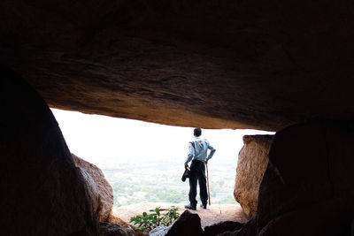 Rear view of man standing on rock