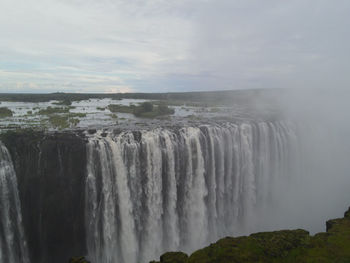 Scenic view of waterfall against sky