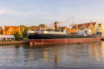 Scenic view of river by buildings against sky