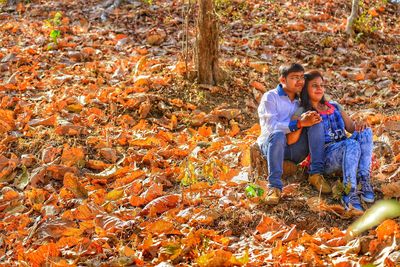 Young couple sitting on rock in forest