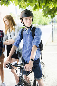 Teenagers with bicycles walking in city