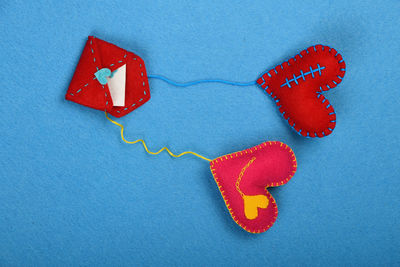 Directly above shot of heart shape craftwork with envelope on table