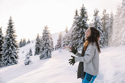 Young woman standing on snow covered field