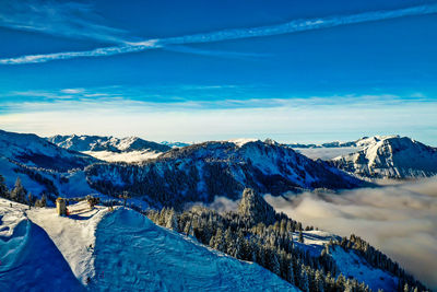 Scenic view of snowcapped mountains against blue sky