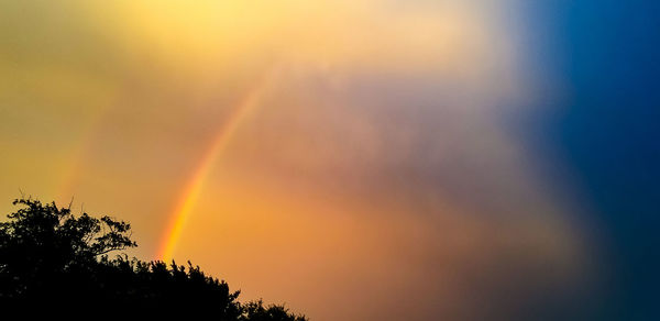 Low angle view of rainbow against sky during sunset