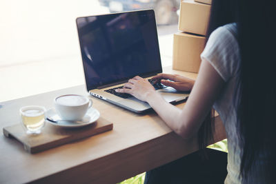 Midsection of man using laptop on table