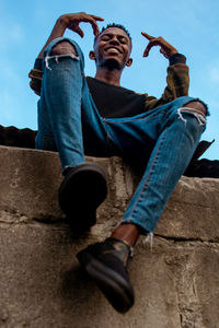 Low angle view of man sitting outdoors