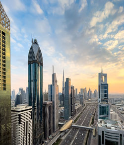 Modern buildings in city against sky during sunset