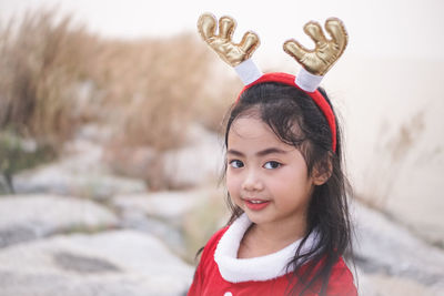 Portrait of cute girl wearing red dress and headband