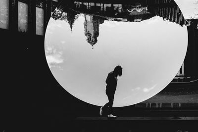Reflection of man in water against sky