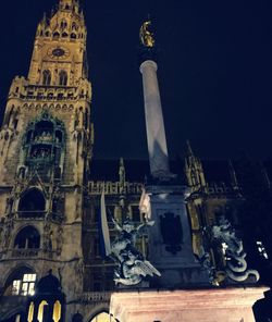 Low angle view of clock tower at night