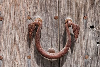 Close-up of rusty doorknob on old wooden door