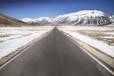 View of the long and straight panoramic road leading to castelluccio di norcia in central italy
