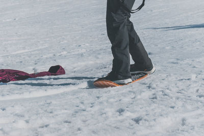 A close-up shot of a caucasian man sliding down a slope on a snow skate at a ski resort in france